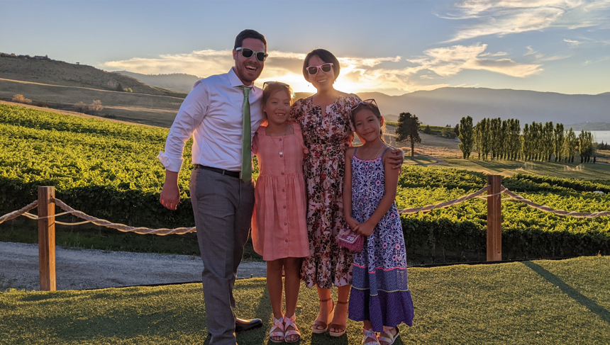 Becky Yu poses with her husband and two daughters outside at sunset
